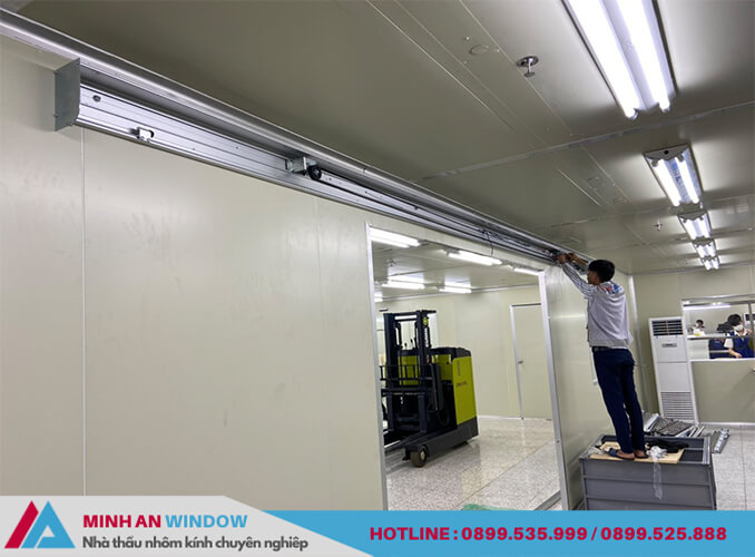 Nhân viên của Minh An Window đang lắp đặt thiết bị cửa tự động Woosung cho nhà kho