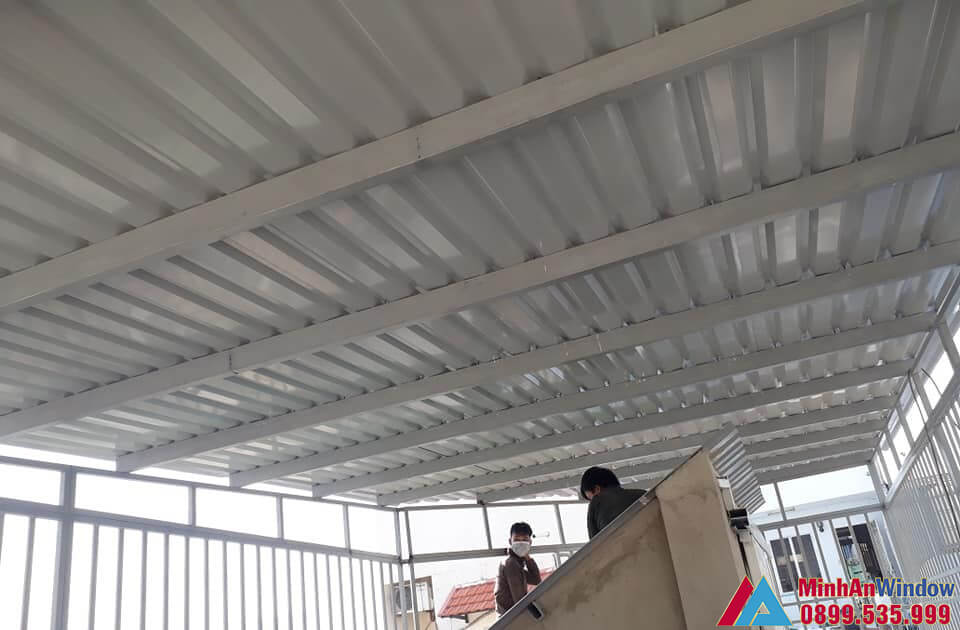 Nhân viên của Minh An Window lắp đặt mái tôn che sân trước nhà cho nhà ở