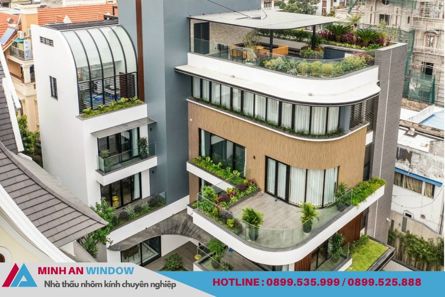 Công trình nhà phố hiện đại sử dụng hệ cửa nhôm kính và lan can kínhHình ảnh công trình nhà phố hiện đại với thiết kế nhiều tầng, ban công rộng và hệ cửa nhôm kính bao quanh mặt tiền. Các bộ cửa đi và cửa sổ được lắp đặt đồng bộ, sử dụng khung nhôm định hình kết hợp kính an toàn nhằm đảm bảo độ bền, khả năng cách âm và lấy sáng tự nhiên tối đa